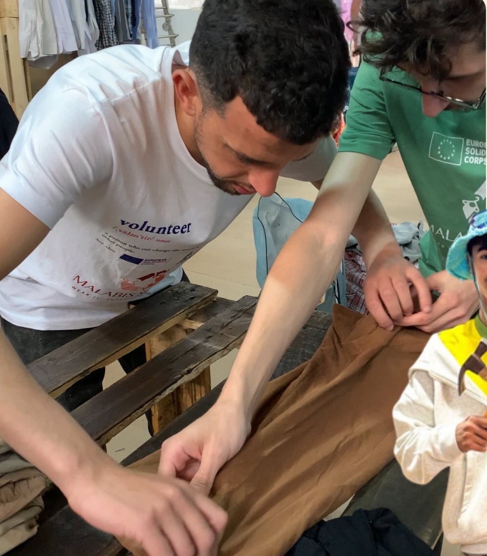A volunteer repairing clothes
